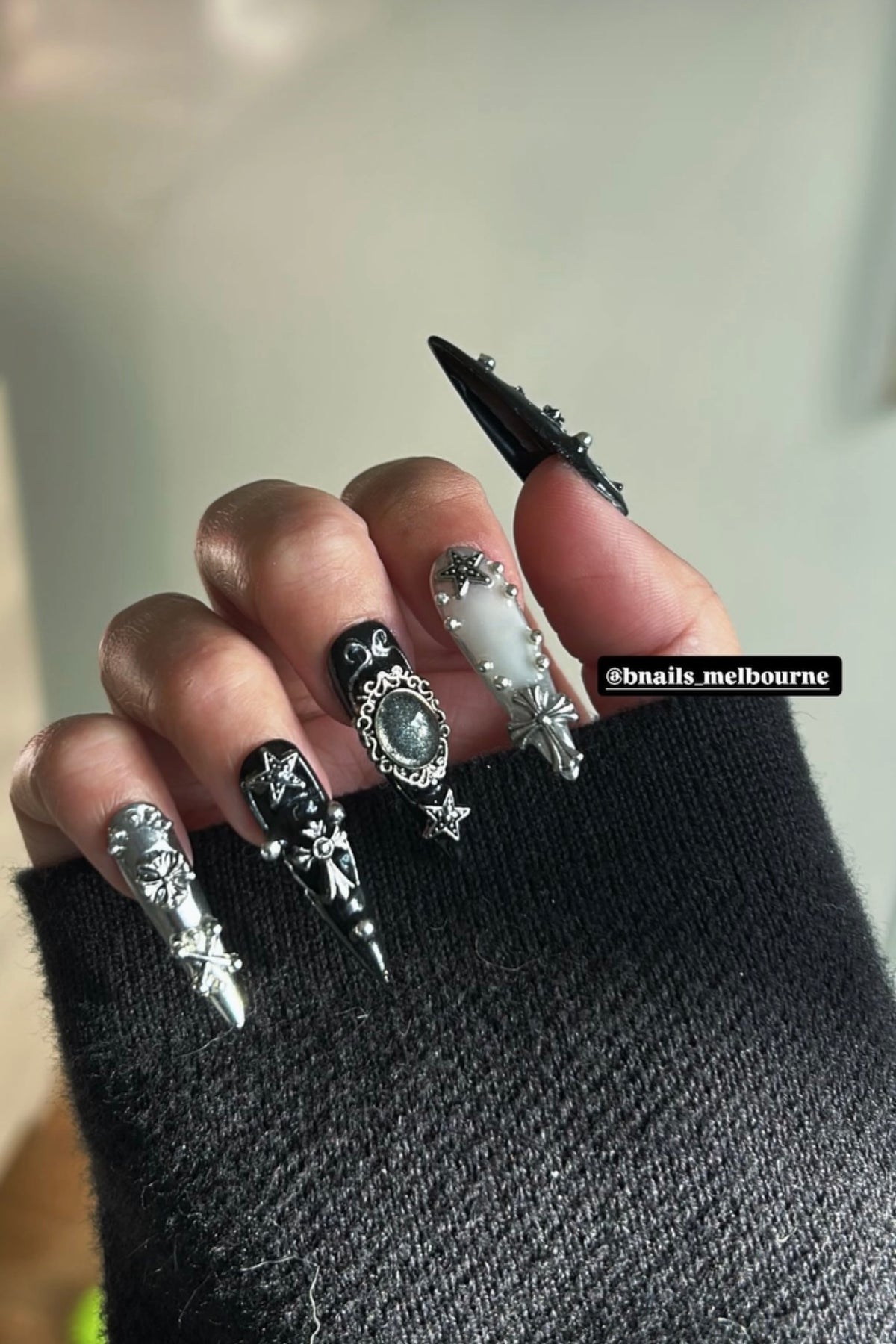 Customer wearing black and silver embellished long press-on nails