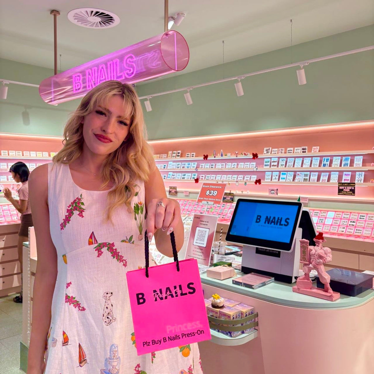 A customer at BNAILS Melbourne Central with a pink B NAILS shopping bag